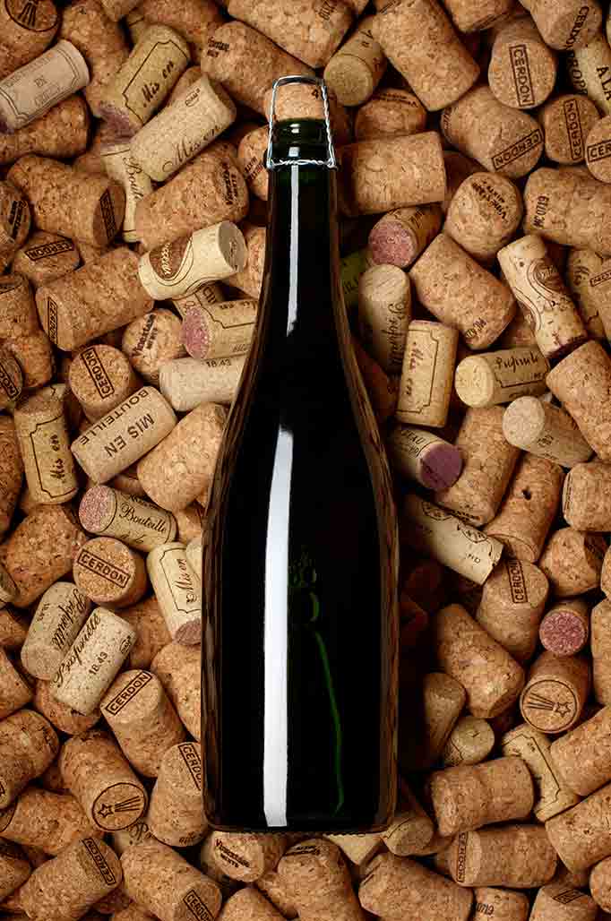 Bouteille de vin effervescent sur un lit de bouchons